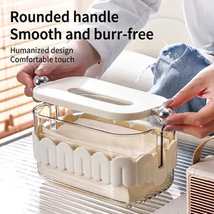 Modern cream-colored tissue box with transparent body and metallic sphere handles