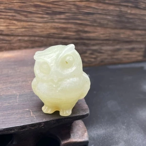 3.5cm natural yellow jade owl figurine displayed on a rustic dark wooden base