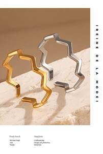 Detailed view of wave shaped 18K gold and silver rings on natural stone background