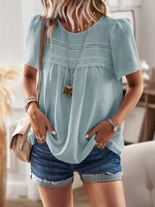 Close-up detail of light blue short sleeve blouse with lace stitching and dot texture