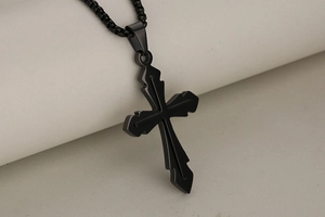 Macro view of a black stainless steel cross pendant necklace with metallic luster