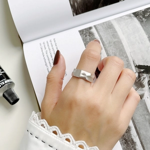 Minimalist wide silver open ring with textured hammered surface on woman's hand