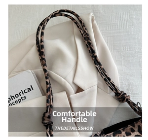 Detail of leopard print tote bag featuring a knotted fabric strap and metal ring