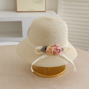 Detail of beige straw sun hat featuring white lace bow and delicate 3D silk roses