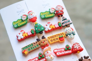 Christmas hair clips set with Santa, elk, and tree motifs on white card display