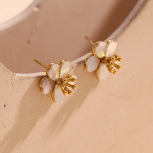 Macro detail of 18K gold plated stainless steel cherry blossom stud earrings with white mop