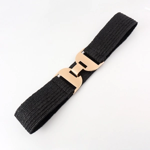 Detail of black elastic woven belt featuring a shiny gold-toned geometric interlocking buckle