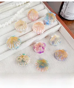 Detail view of shell-shaped acetate hair claws with marble texture and golden line accents