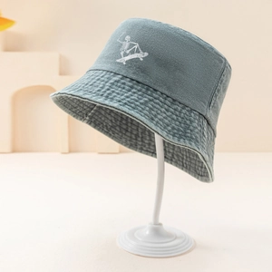Detail view of washed denim bucket hat with skull skateboard embroidery on cotton