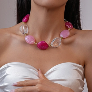 Close-up of pink and translucent irregular acrylic beads on a stylish chunky necklace