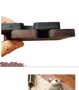 Detail comparing laser-cut and CNC-machined edges of black walnut wood tea coasters
