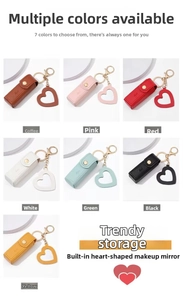 Detail view of mini leather lipstick pouch with heart mirror charm and metal keychain