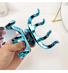 Detailed view of the bright blue metallic hair claw with unique octopus tentacle design