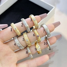 Detail of ten stackable zircon rings in gold and silver finish with star patterns