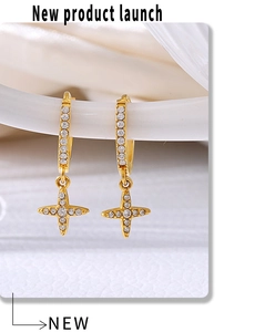 Close-up of gold hoop earrings with star pendants and pavé set cubic zirconia crystals