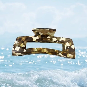 Close-up of tortoise shell pattern acetate hair claw clip with seaside background