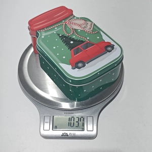 Detailed weight measurement of a Christmas car pattern tin jar on a digital scale