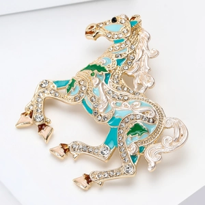Detailed close-up of a horse brooch with green enamel and sparkling white rhinestones