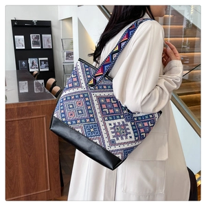 Detail showing colorful geometric patterns and black PU leather base on tote bag