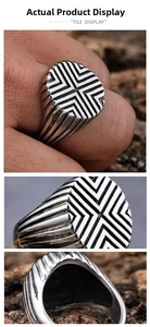 Detailed view of men's silver geometric ring with industrial cross lines and side grooves