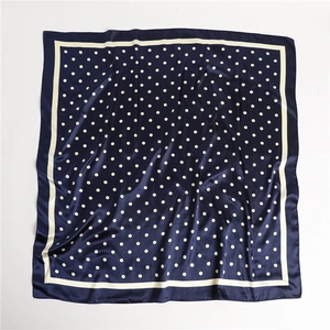 Detail view of navy blue polka dot satin scarf with premium white border stitching