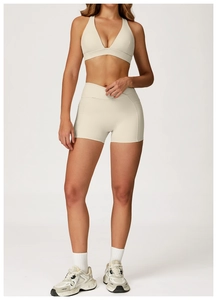 Detail of beige yoga set with cross waist high-rise shorts and functional side pockets