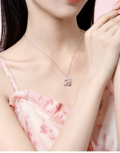 Close-up of S925 silver necklace featuring floral butterfly pendant with pink gemstone