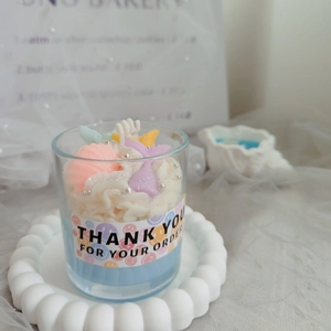 Handmade strawberry chocolate scented candle in glass cup with shell decorations