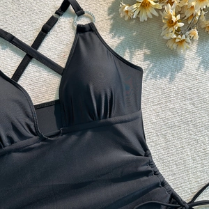 Détail d'un maillot de bain noir avec poitrine froncée et anneau en strass élégant