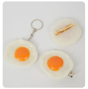 Vue détaillée de porte-clés et barrettes en forme d'œuf sur le plat avec clip en métal
