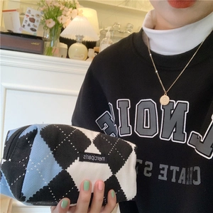 Close-up of argyle pattern stationery pouch with zip and merciparis label detail