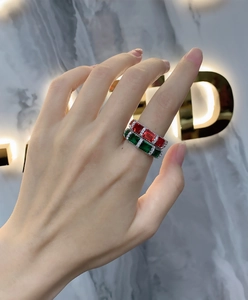 Detail of S925 silver rings with emerald and ruby cut stones on model's hand
