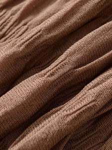 Macro detail of dark brown fine knit fabric with professional pleated texture and soft drape