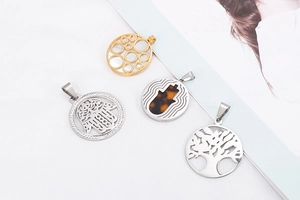 Macro shot of assorted stainless steel tree of life and hamsa hand pendants with crystals