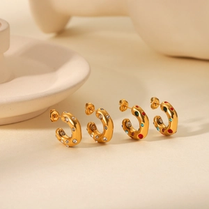Detailed close-up of C-shaped 18K gold earrings set with vibrant multicolor zircons