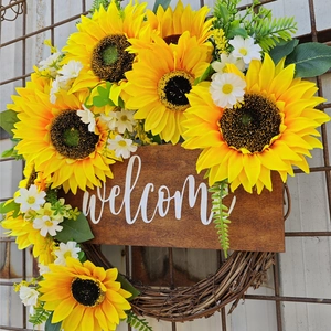 Gros plan d'une couronne de tournesols rustique avec panneau welcome et verdure
