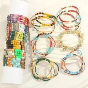 Close-up of Bohemian colorful beaded bracelets with enamel charms and star pendant