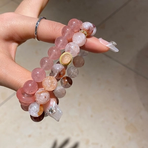 Close-up of beaded strawberry quartz and agate bracelets with gold spacer beads