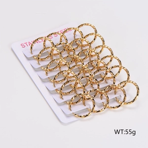 Macro detail of twisted gold stainless steel hoop earrings set on a white display card