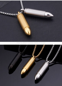 Macro detail of bullet pendant necklaces in gold, silver and black finishes on dark surface