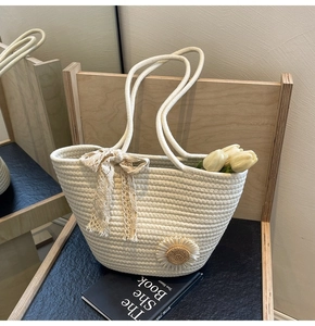 Detailed close-up of cream woven tote bag featuring lace bow and sunflower floral patch