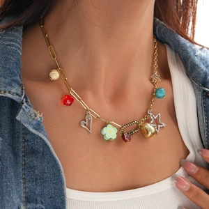 Detail of a gold layered necklace with heart, flower charms, and colorful beads