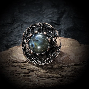 Macro shot of natural labradorite gemstone set in a vintage wire-wrapped bird nest ring