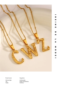 Detailed close-up of golden alphabet pendants with hammer texture on a white plate