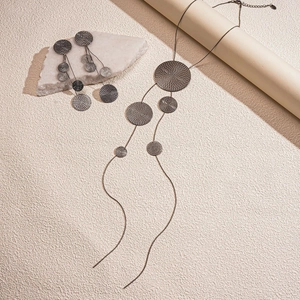 Detail of long fringe necklace and earrings with textured gunmetal grey round discs