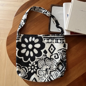 Close-up of bohemian linen tote featuring vintage floral patterns and branded woven label