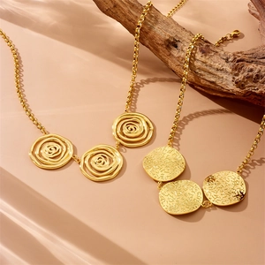 Vintage 18k gold plated stainless steel spiral and hammered pendant necklace on wood
