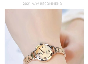 Close-up of golden quartz watch with Roman numerals on a female wrist under soft light