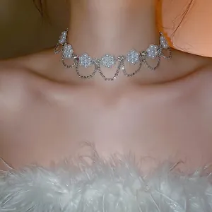 Elegant pearl flower necklace with rhinestone tassels shown on a model neck