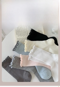 Detailed flat lay of multi-color mesh crew socks with ruffle edges and knit texture